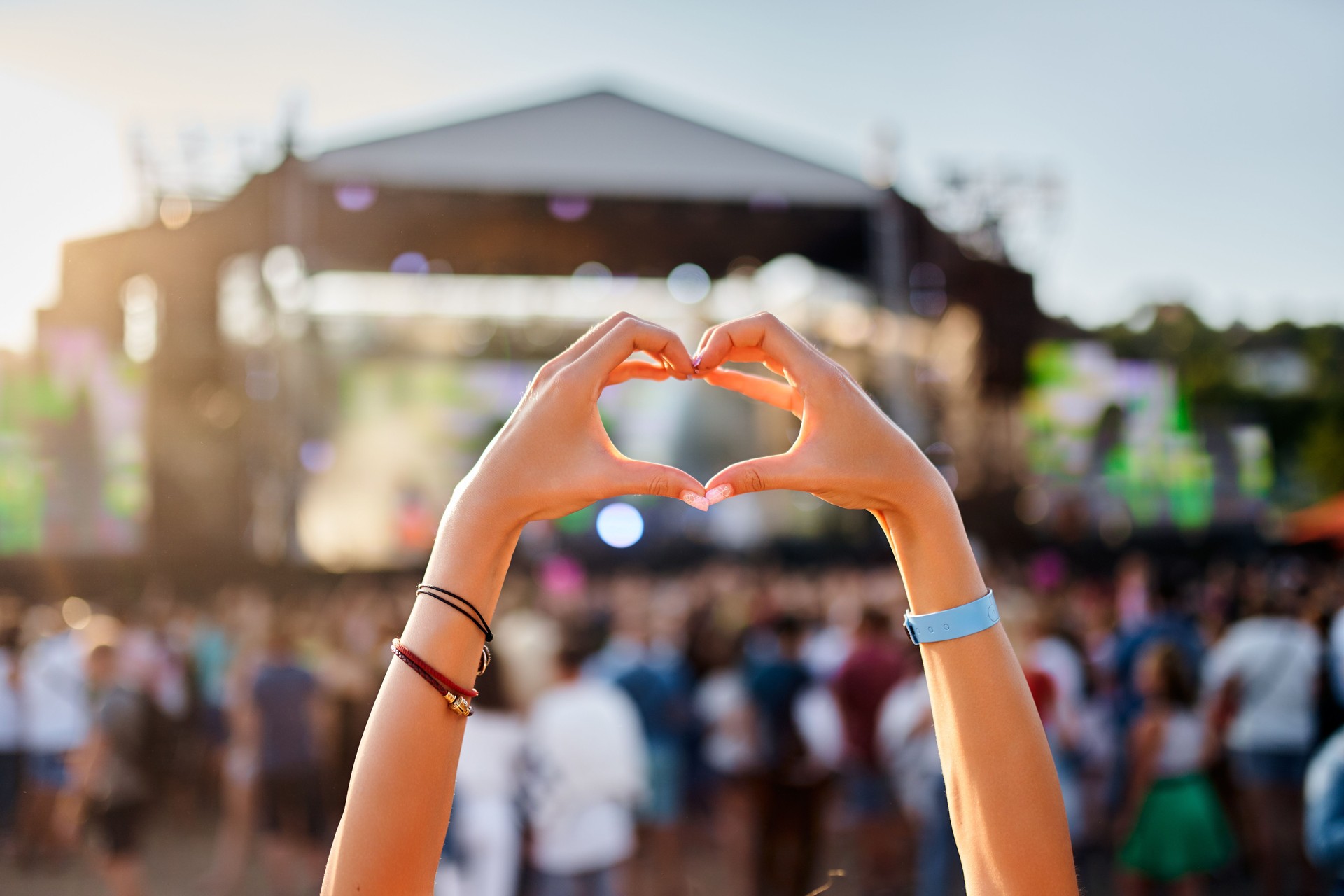 Le spectateur forme une forme de cœur avec les mains lors d’un festival de musique au bord de la plage, la foule profite d’un spectacle en direct au coucher du soleil, d’un geste de symbole d’amour lors d’un événement estival, d’une célébr